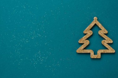 Noel kompozisyonu. Mavi üzerine altın oyuncak Noel ağacı. Düz konum, üst görünüm, kopyalama alanı