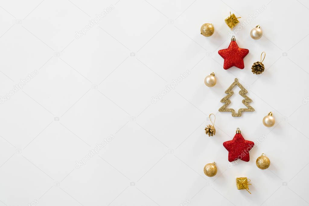 Flat composition with gold and red Christmas toys, balls and cones, festive decor on a white background. Christmas new year card with copy space for text and greetings