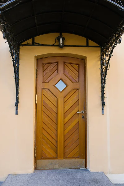 Wooden door to the house and porch with a canopy
