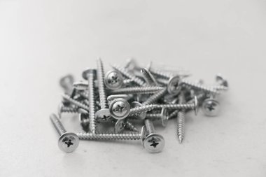 Metal vidalar gri arka planda üst üste yığılır. Yapı bağlayıcıları