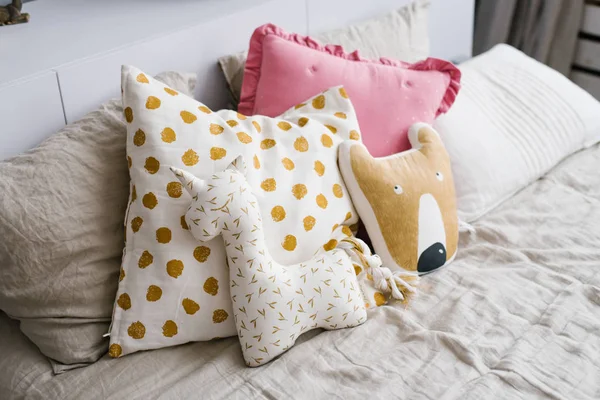 Funny unicorn pillows on the bed in the children\'s room