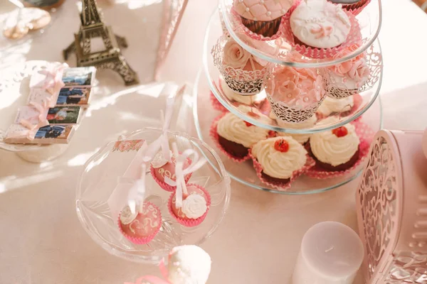 Kolorowe białe i różowe babeczki ozdobione na stole na uroczystość weselną miłości, z wisienkami, śmietaną i wisienką jako dekoracjami, słodką alternatywą dla tradycyjnego tortu weselnego — Zdjęcie stockowe