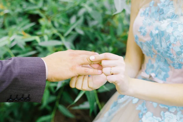 Bruden bar en ring till brudgummen. nygifta med ringar på fingrarna på bröllopsdagen bröllopsceremoni närbild. — Stockfoto