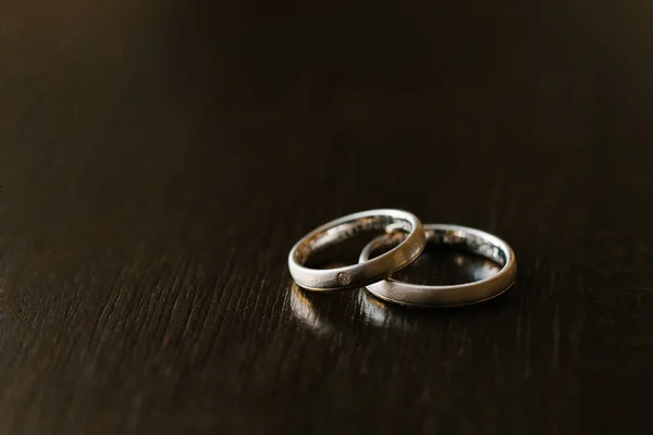 Anillos de compromiso de boda de cerca en la estructura de madera marrón — Foto de Stock