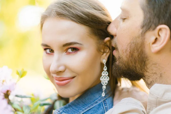 Man in love whispers beautiful words in the ear of his beloved g — Stock Photo, Image