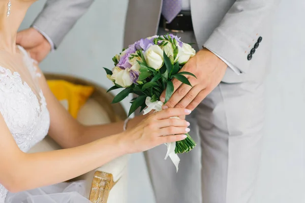 Bruidegom geeft de bruid een bruiloft boeket, een close-up van de handen — Stockfoto