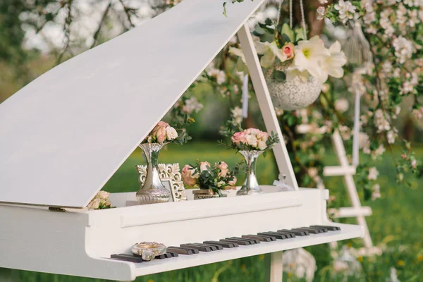 Düğün tasarımında dekoratif beyaz Grand piyano ya da baharda romantik bir akşam yemeği için dekor.