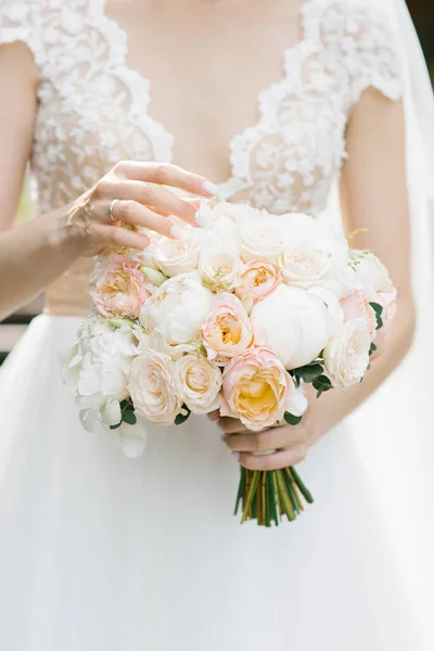 Bruid raakt haar vingers aan de bloemen in de bruiloft boeket, — Stockfoto