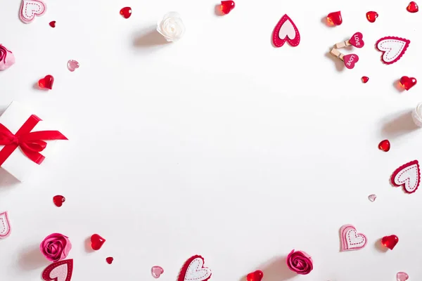 A gift frame with a red bow, beads, glass and felt hearts on a w — Stock Photo, Image