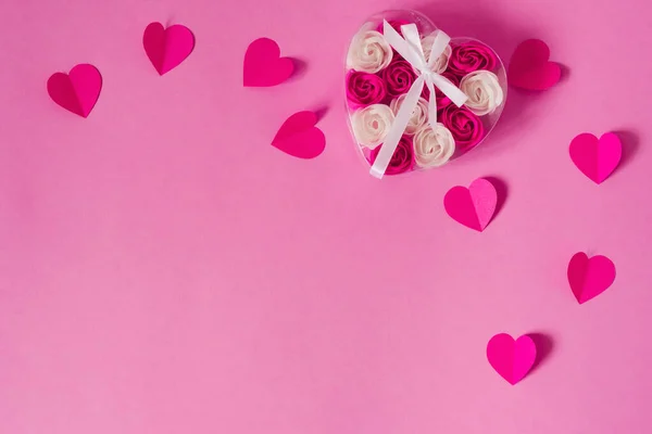 Paper pink hearts and a transparent box with pink and white rose — Stock Photo, Image
