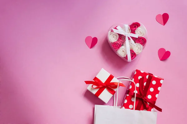 Valentine\'s Day. White paper bag with gifts and paper hearts wi