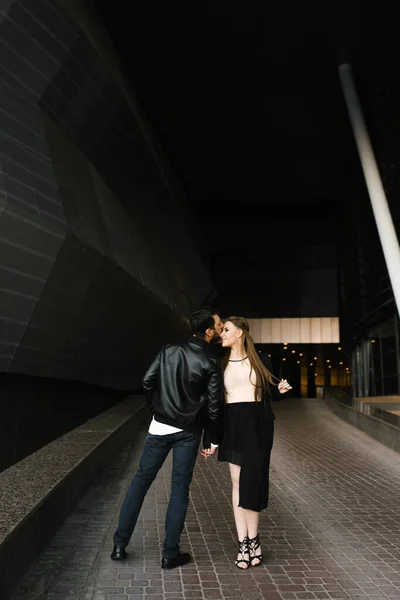 Um casal apaixonado em roupas formais escuras passeia pela cidade — Fotografia de Stock