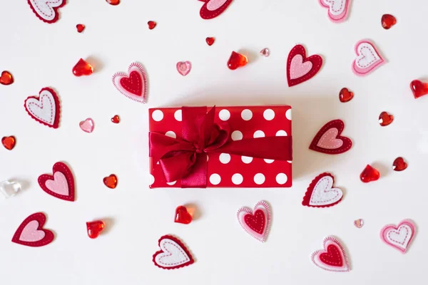 Gift with a red satin ribbon and a heart on a white background. — Stock Photo, Image