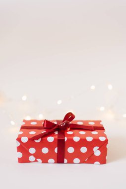 Kırmızı kurdeleli hediye kutusu ve beyaz arka planda cam kalp.