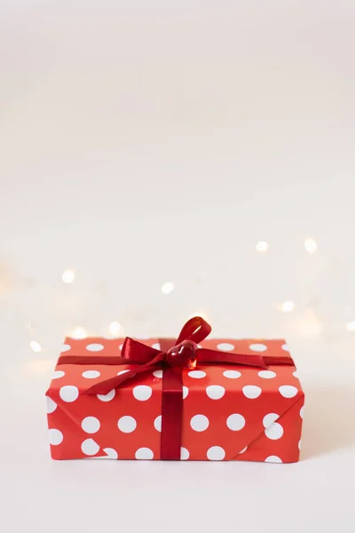 Gift box with red ribbon and glass heart on white background — Stockfoto