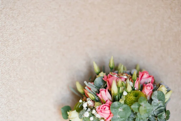 Bröllopsringar av bruden och brudgummen ligger på blommorna i w — Stockfoto