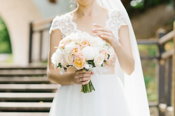 Beautiful wedding bouquet of peony roses, peonies in the hands