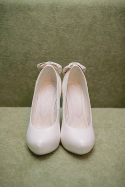 Women's white shoes on a green background