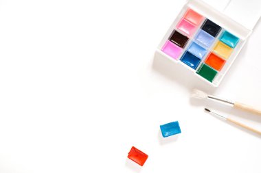 Watercolor paints in ditches and in box and city on a white back