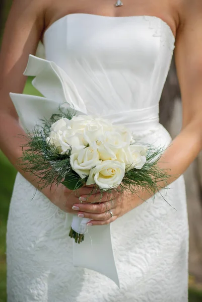 Delicate beautiful wedding bouquet of white roses and greenery i