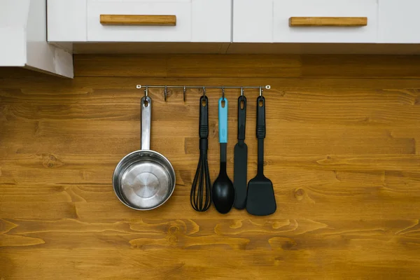 Accesorios para cocinar cuelgan de un soporte de metal en la cocina: s — Foto de Stock