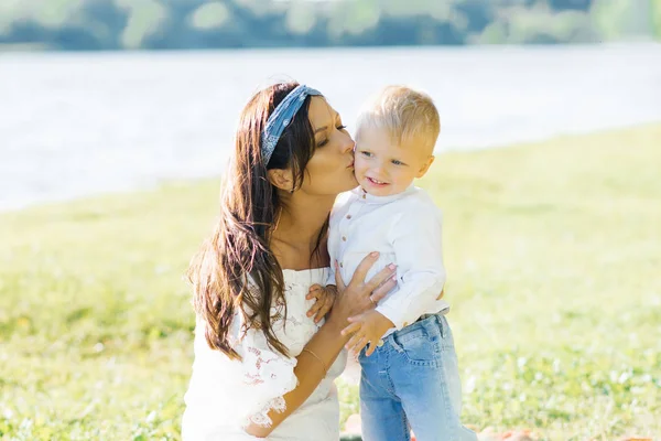 Anne iki yaşındaki oğlunu yanağından öpüyor. — Stok fotoğraf