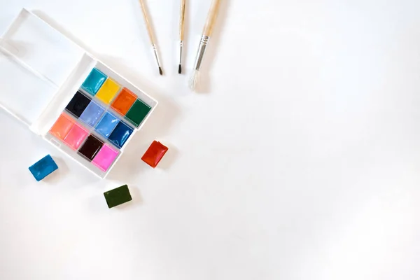 Pinturas de acuarela en zanjas y en caja y ciudad sobre una espalda blanca — Foto de Stock