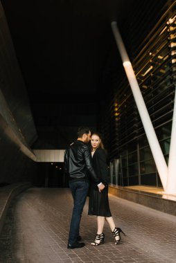 Siyah deri ceketli bir adam ve siyah ceketli bir kadın.