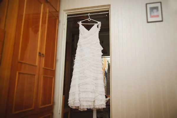 De trouwjurk hangt aan een hanger in de kamer.. — Stockfoto