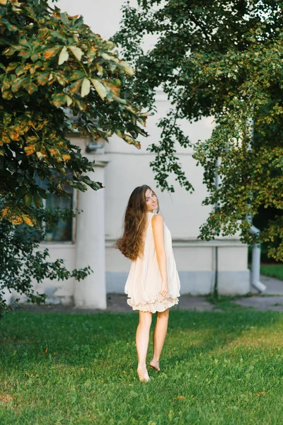 Bella giovane donna o ragazza in un abito leggero volante corre a piedi nudi — Foto Stock