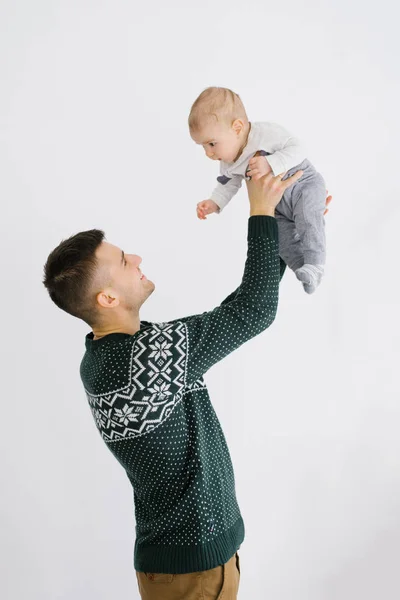 Jovem pai segura seu filho de cinco meses de idade em seus braços contra um — Fotografia de Stock