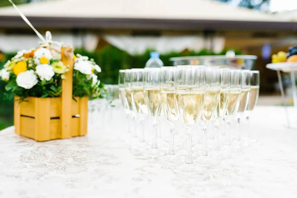 Many glasses of champagne on the buffet table and a basket of fr — 스톡 사진