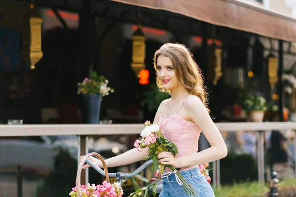 Una bella giovane donna in gonna di jeans e top rosa cammina thro — Foto Stock