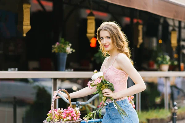 Una bella giovane donna in gonna di jeans e top rosa cammina thro — Foto Stock