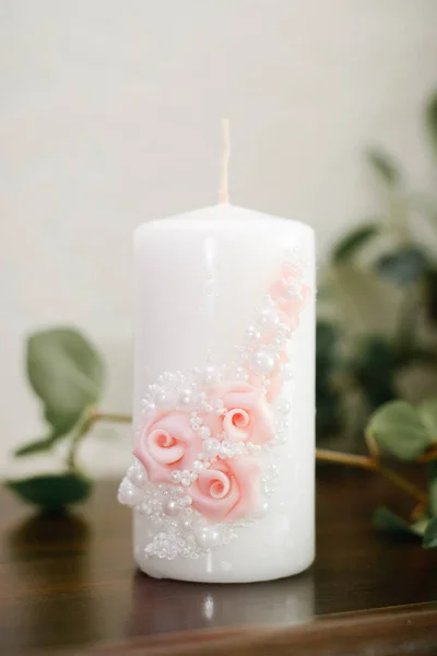 wedding white candle with a decor of pink roses and white beads