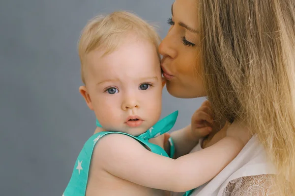 Uma jovem mãe beija o filho de um ano. Dia da mãe e chi — Fotografia de Stock