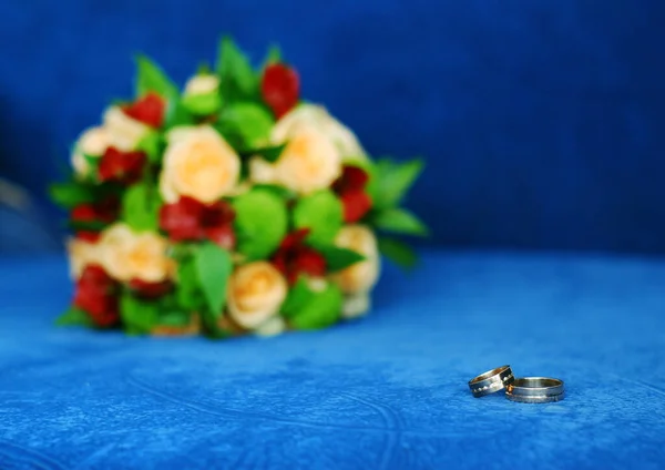 Beautiful wedding rings lie on a blue background, a bright weddi — Stock Photo, Image