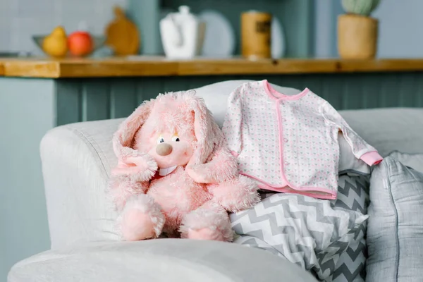 Una blusa de bebé para un bebé está acostado en el sofá y un rosa suave para — Foto de Stock