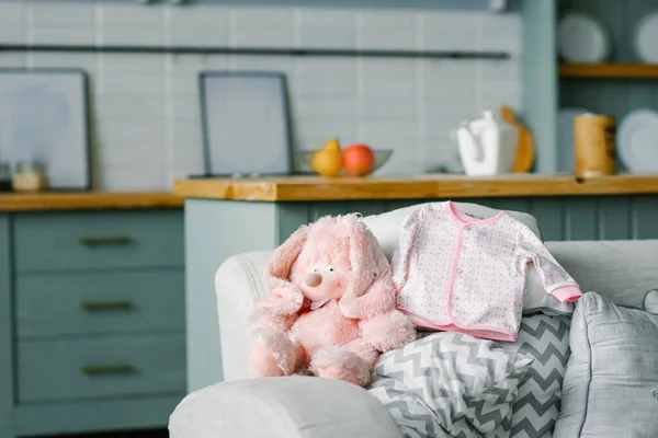 Una blusa de bebé para un bebé está acostado en el sofá y un rosa suave para — Foto de Stock