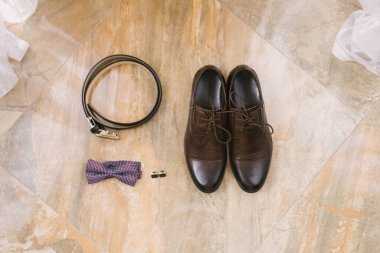Damat için aksesuarlar: Bağcıklı kahverengi ayakkabılar, kol düğmeleri,