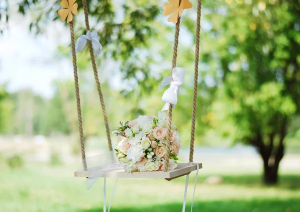 新娘的花束挂在花园的秋千上 美丽而典雅 — 图库照片