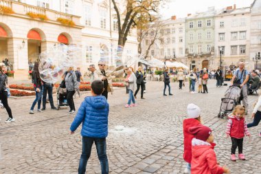 Lviv, Ukrayna. Mart 2020. Pazar meydanındaki sabun köpüğü gösterisinde çocuklar eğleniyor.