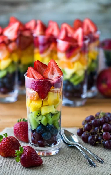 Rainbow fruit salad in tall glasses. — Stock Photo, Image