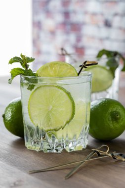 Limonlu ve naneli bir bardak köpüklü su manzarası.