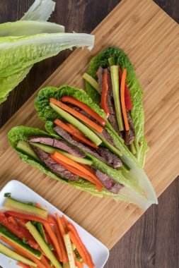 Top down view of lettuce wraps filled with grilled steak and vegetables ready for eating.