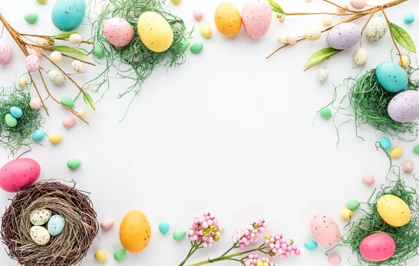 Top down view of an Easter border frame of robins eggs and chocolate eggs with copy space in the middle