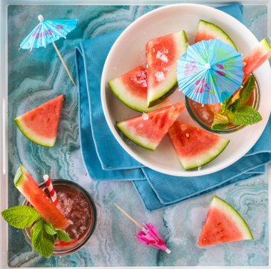 Karpuz kokteylleri tepside karpuz parçalarıyla çevrili..