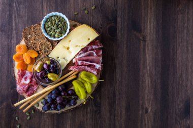 Çeşitli parmak yiyecekleriyle dolu bir Charcuterie tahtasının yukarıdan görünüşü.