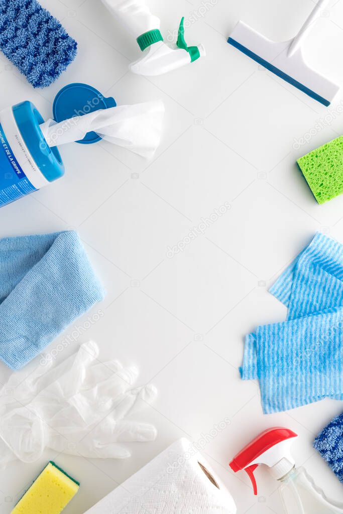A top down view of a variety of house cleaning supplies against a white background.