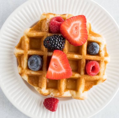 Üstünde böğürtlenler olan Belçika Waffle 'ının en tepeden aşağı görüntüsü..